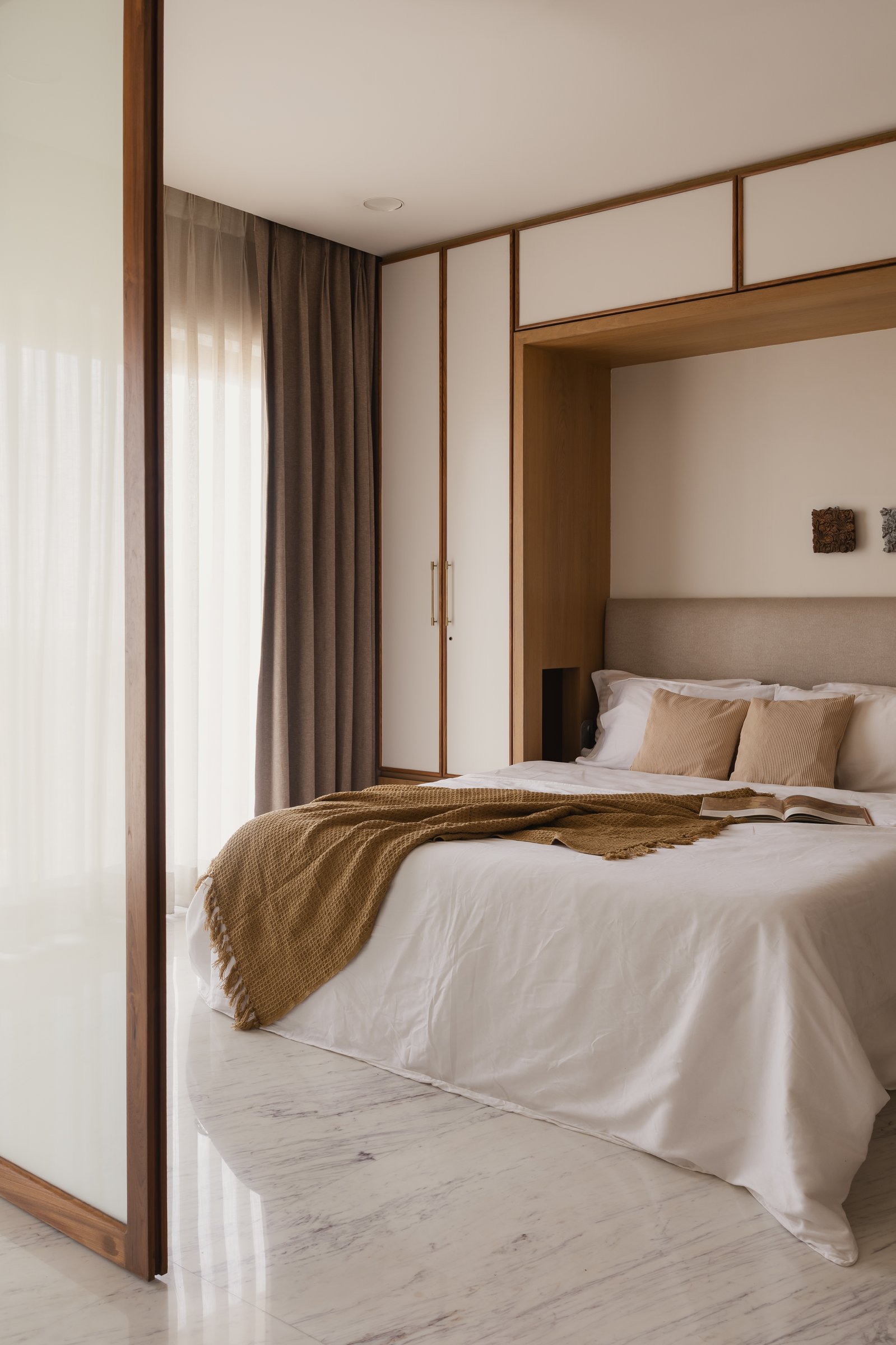 A switchable glass partition to one side of the primary bedroom, hinting at the apartment's flexibility strategy