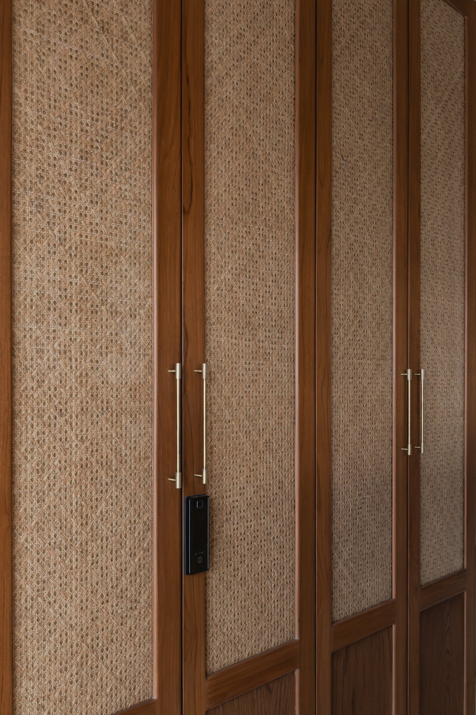 Wardrobe fronts in teak and woven rattan behind glass, a considered response to the brief for indigenous materials