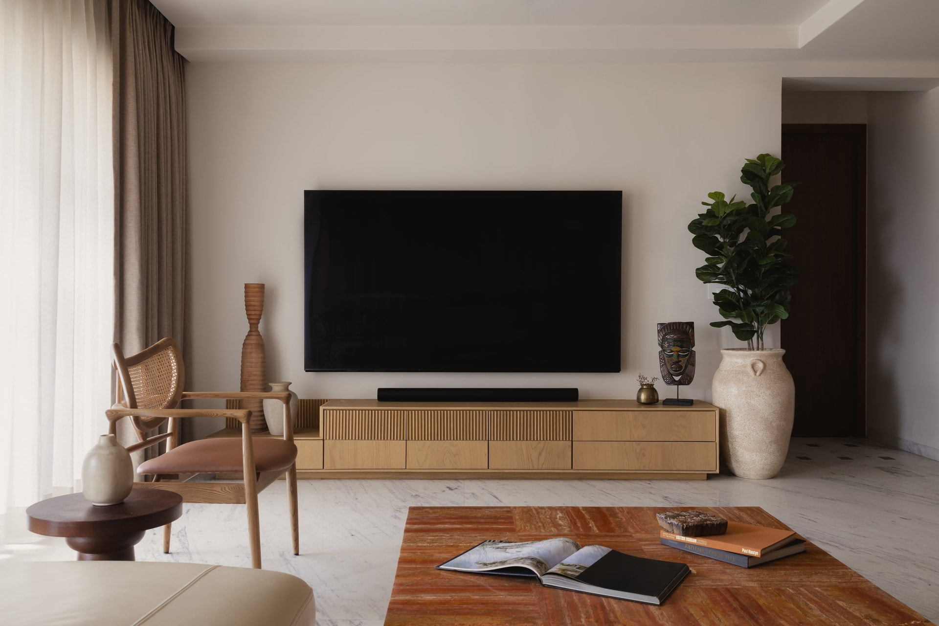 The media wall, restrained to a single reeded oak console and a small gathering of sculptural objects