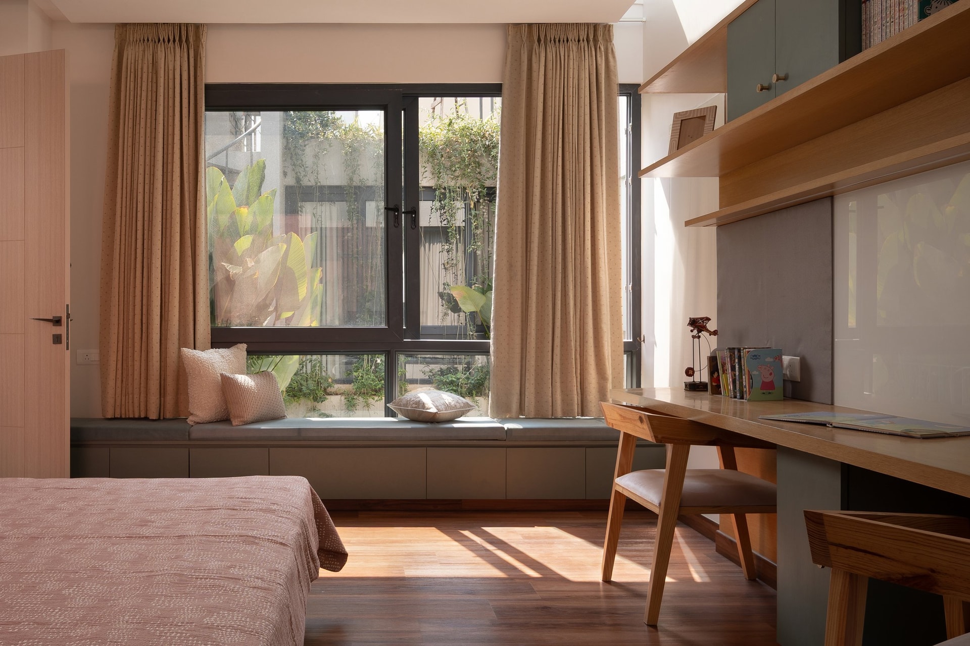A tall glazed opening brings the courtyard’s stone wall and planting directly into the child’s room