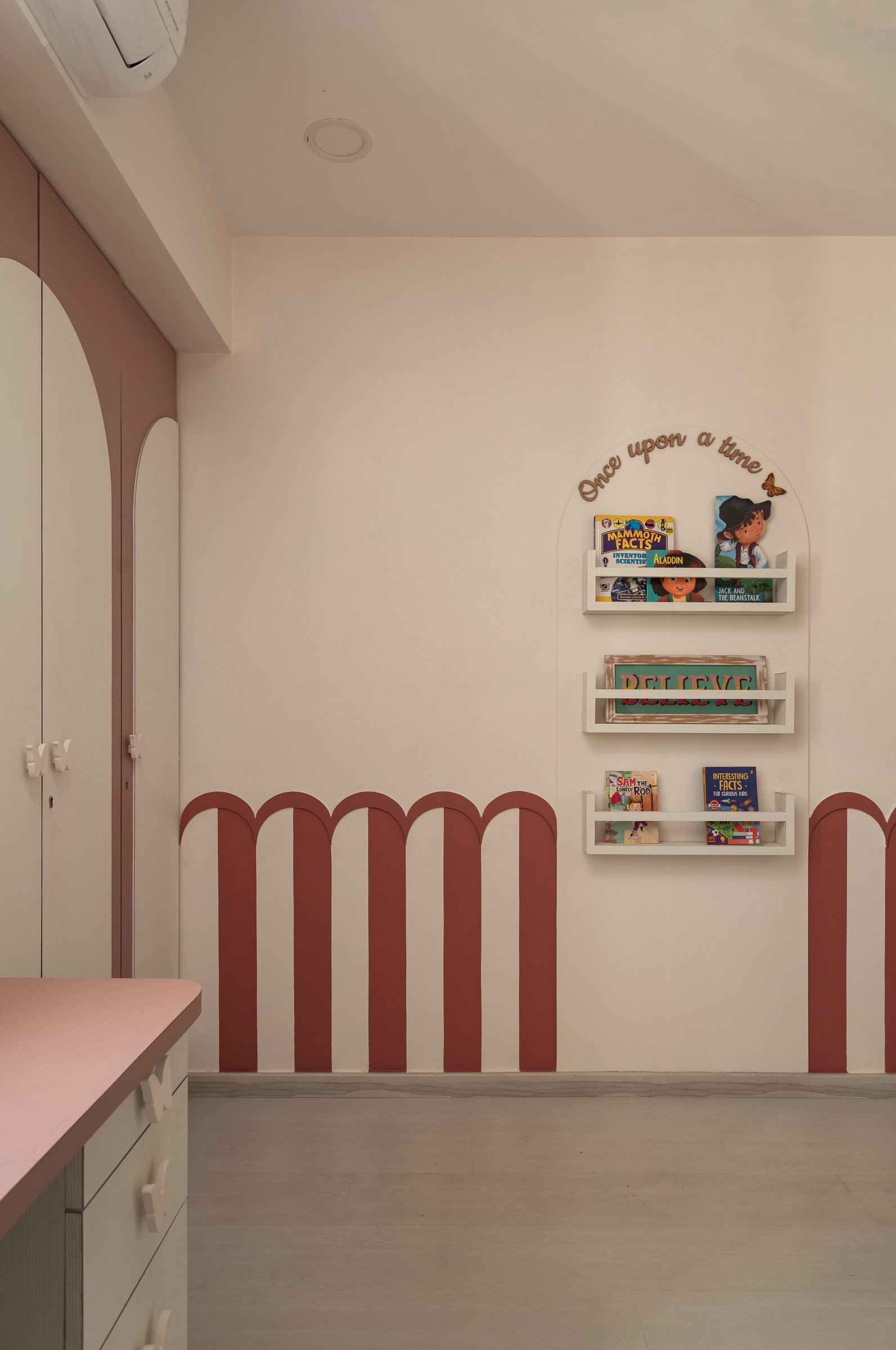 The daughter's room, with a dusty rose arched dado and a painted-arch bookshelf alcove