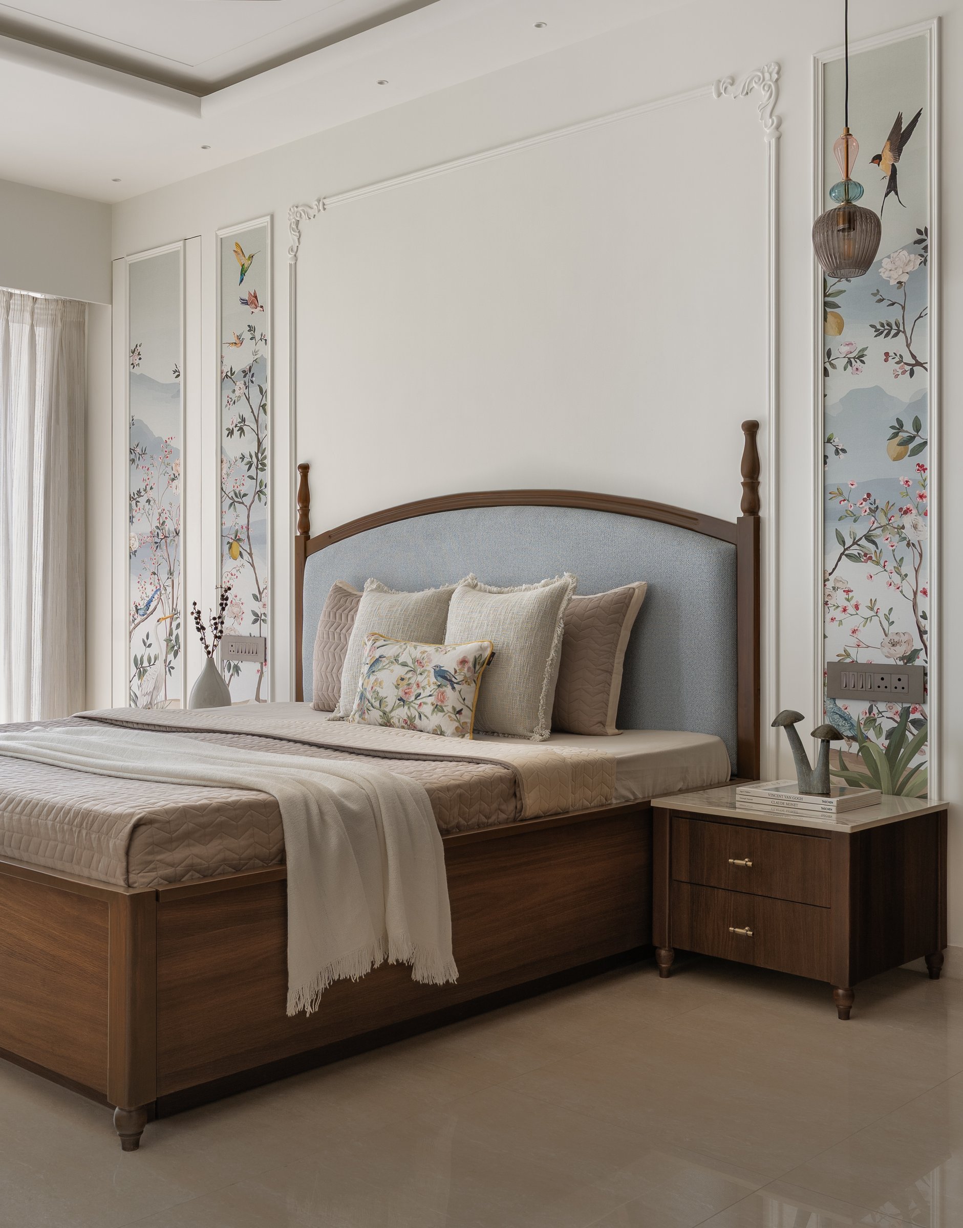 The master bedroom, with a classical turned-post bed, powder-blue headboard and botanical side panels