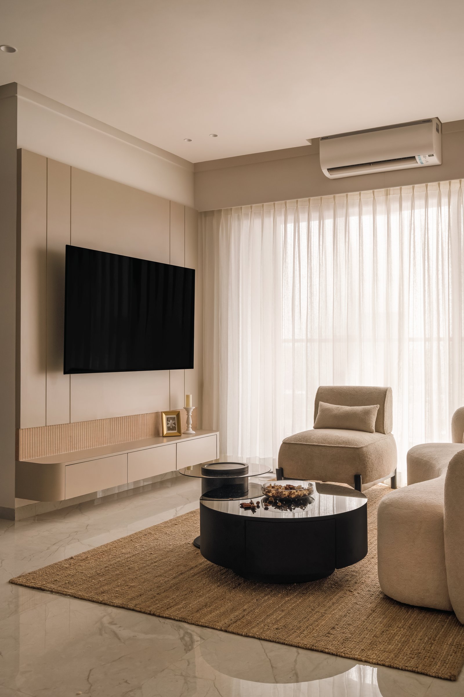 The living room, where a pale media wall and sheer drapery frame a composition shaped by filtered western light