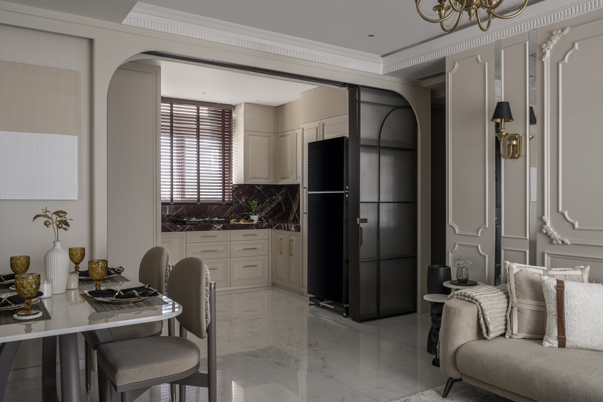 The dining area, with a coffee-brown aluminium-framed reeded glass partition linking the kitchen to the living zone