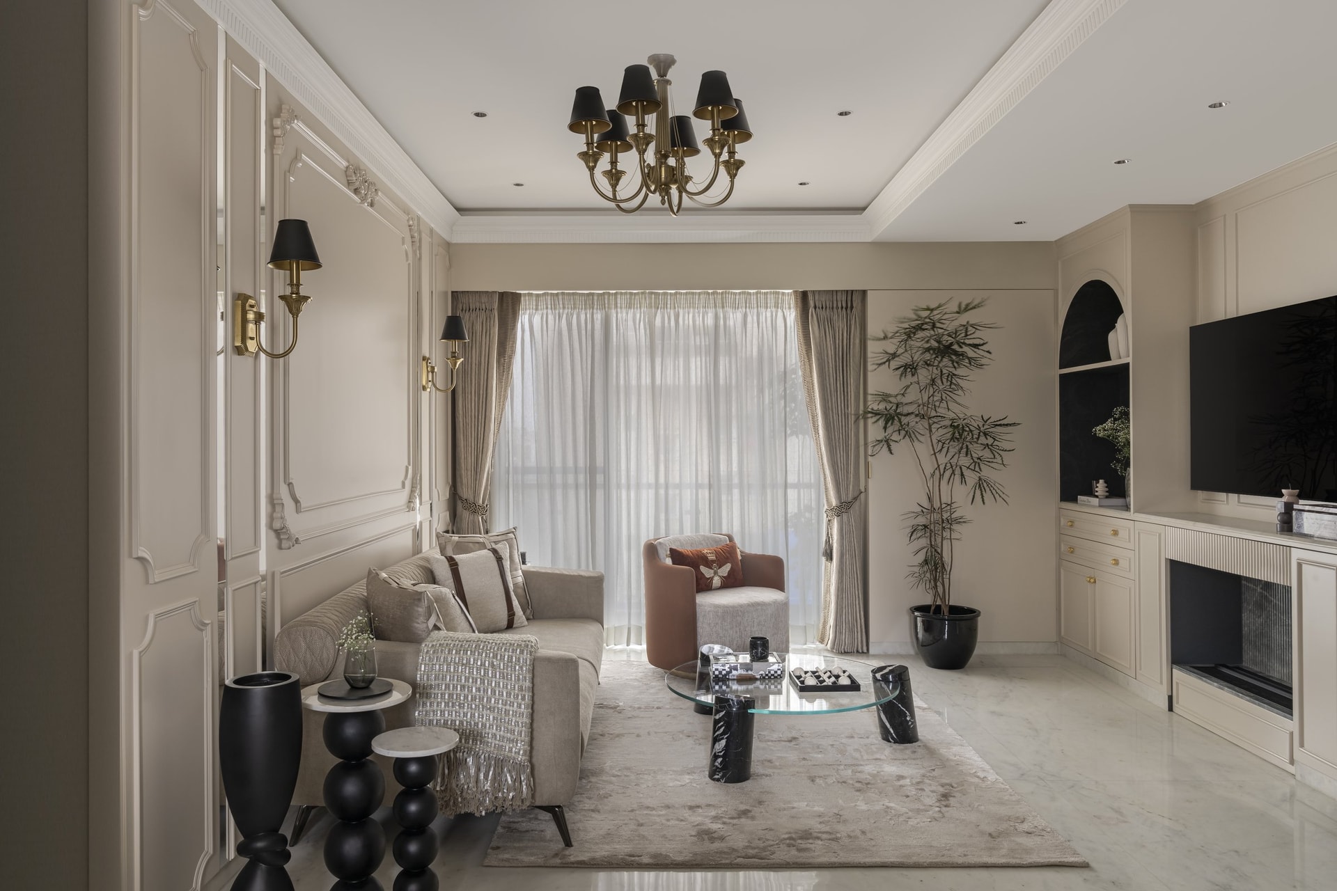 The living room, where moulded wall panelling and a brass chandelier with black shades establish the English note