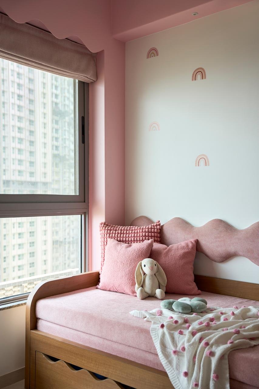The window bench: a wave-edged dusty pink backrest at a child's scale