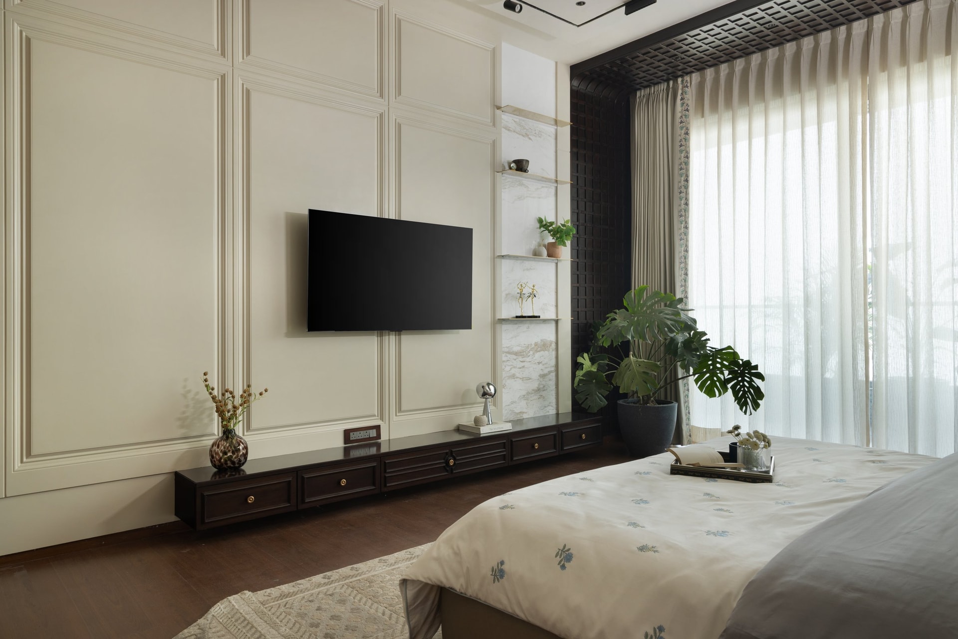 Opposite the bed, a panelled ivory wall and a low ribbed-front console balance classical proportion with contemporary restraint