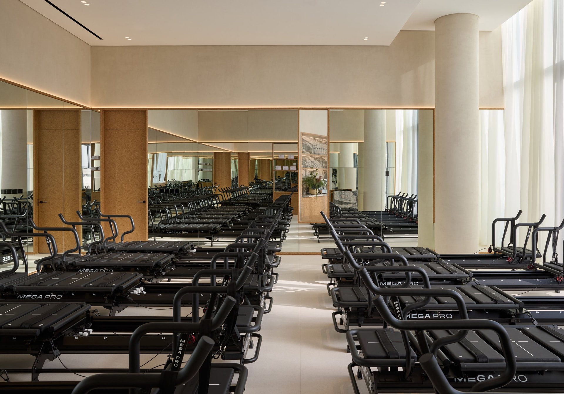 The Lagree studio: rows of reformers held in disciplined order by 360-degree mirrors and micro-cement planes