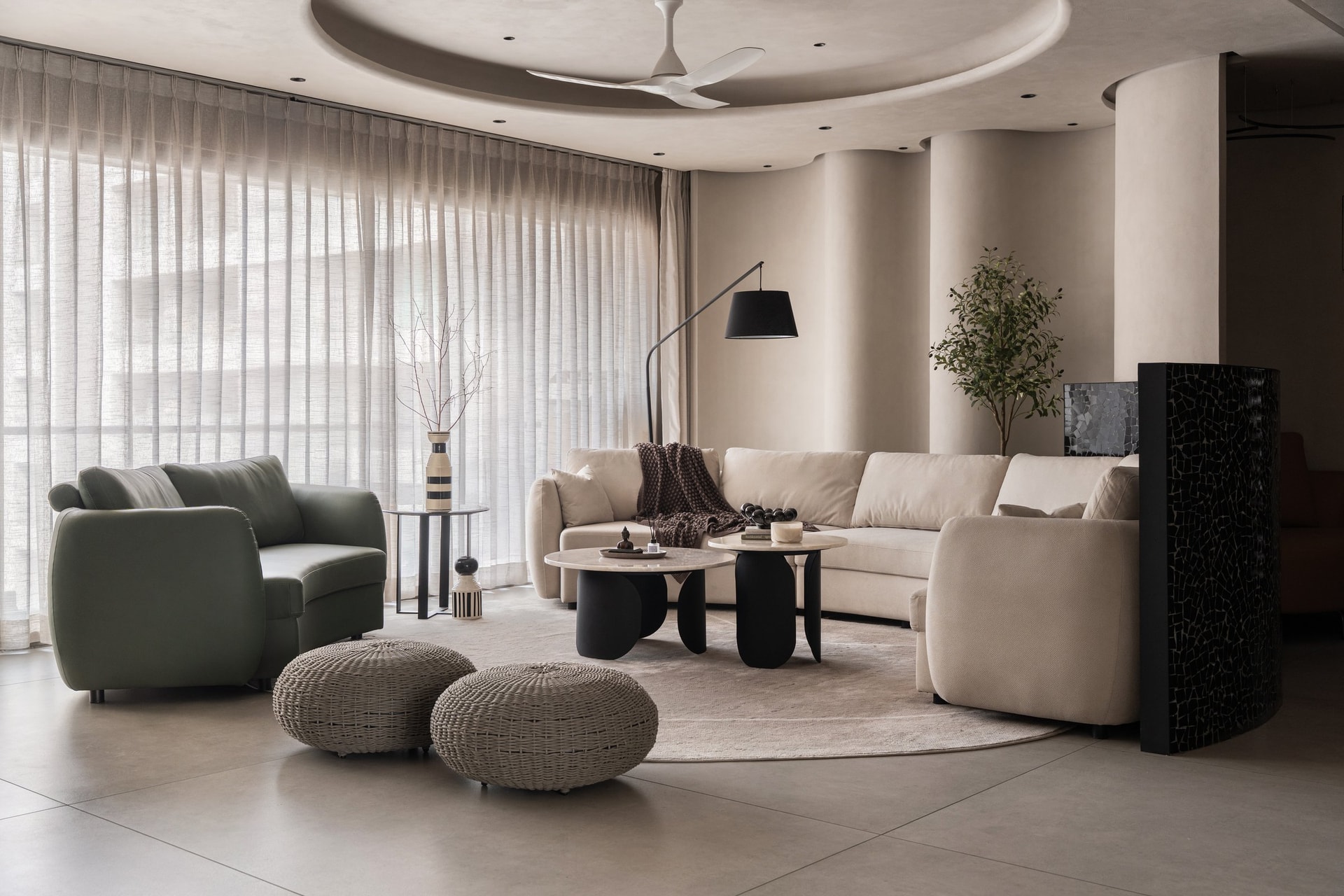 The living room, where a curved sectional follows the arc that runs from wall into ceiling