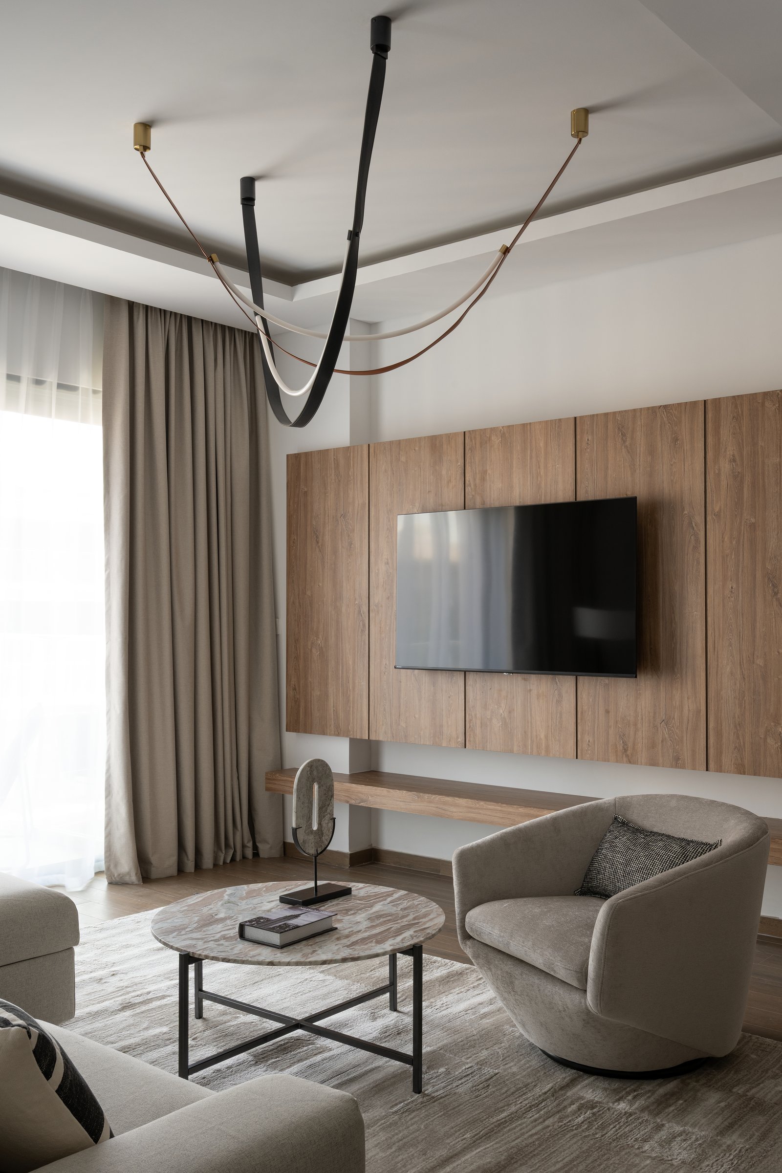 The media wall: panelled wood-grain and a floating ledge let the television recede into the architecture
