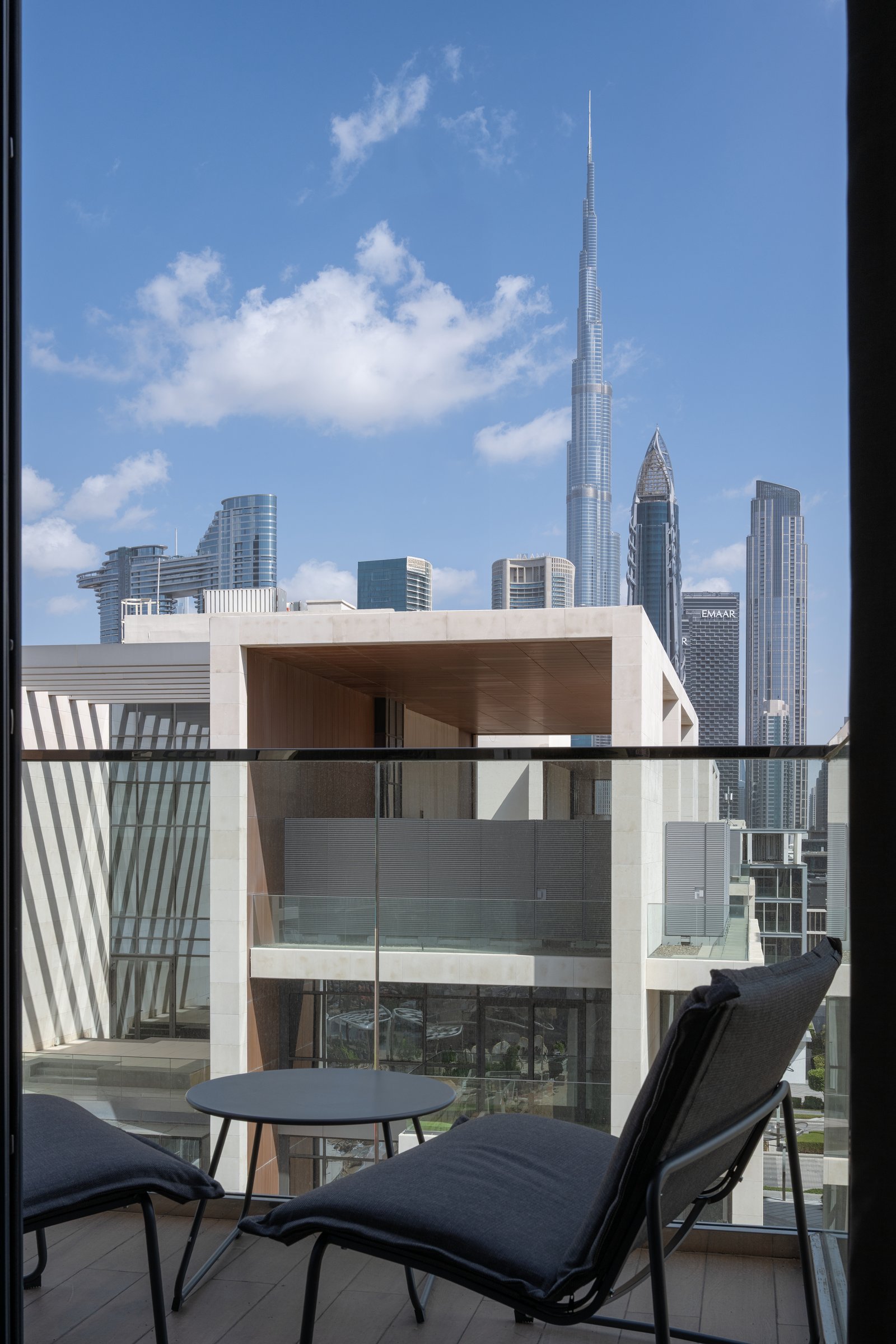 The balcony orients its two slim loungers squarely at the Burj Khalifa, the one place in the apartment where the city is allowed to enter the design