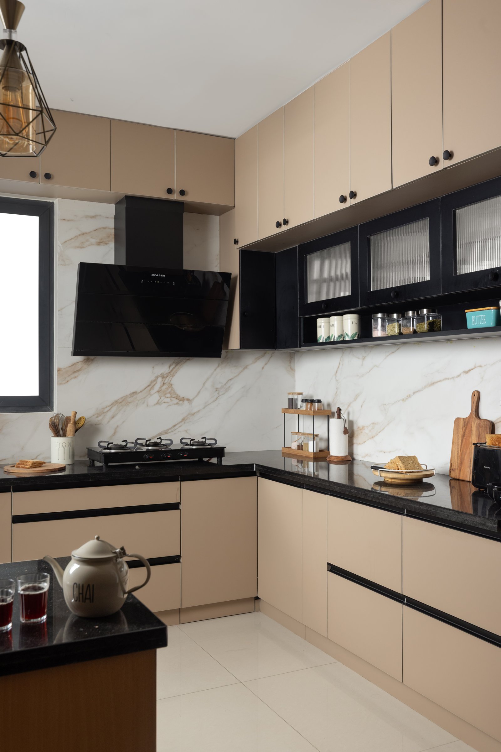 The kitchen's working wall: matte latte cabinetry, a black stone counter and fluted glass uppers framed in black