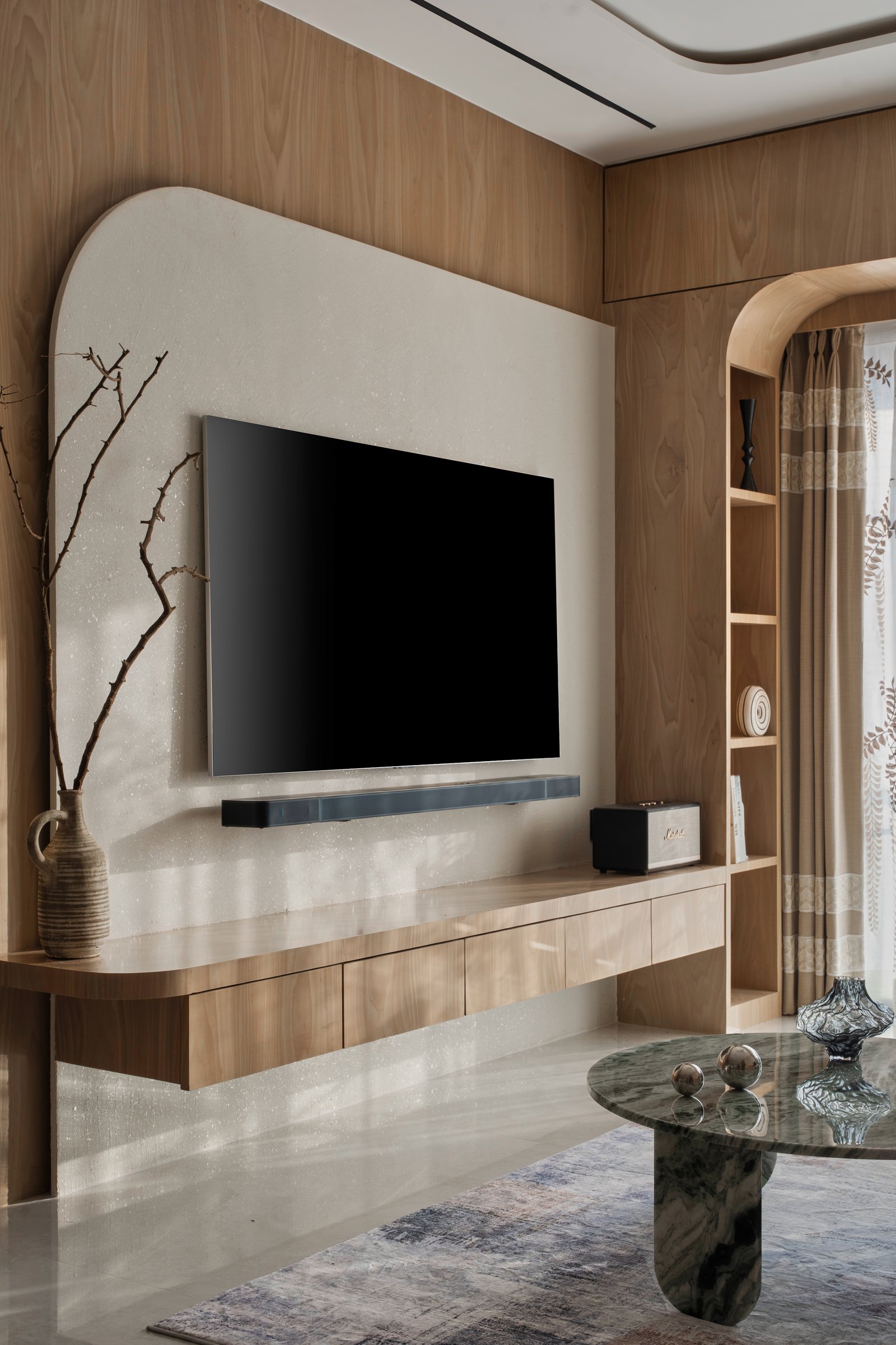 The television wall, where an arched plaster niche replaces the conventional entertainment console