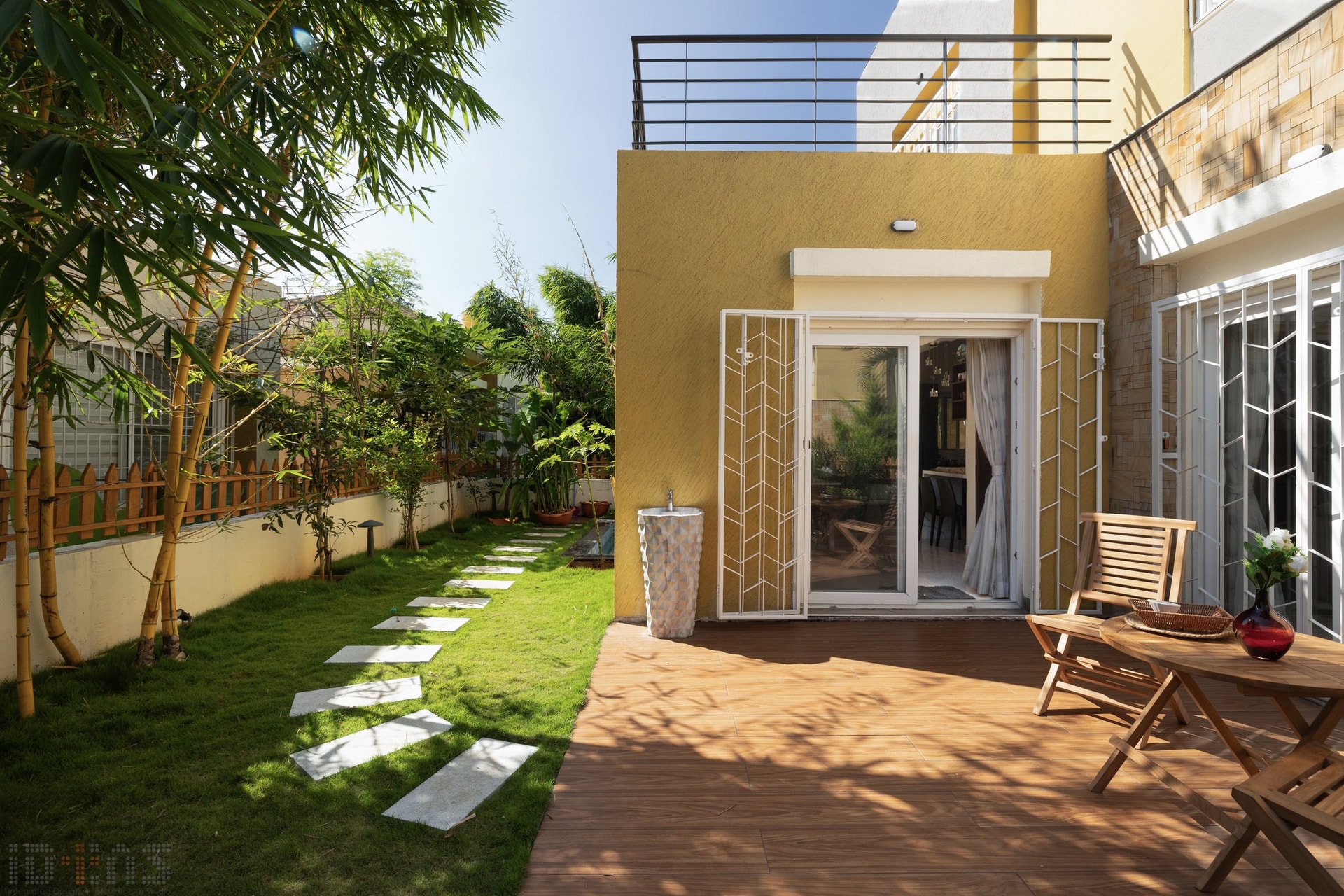 The rear garden: a wood-decked verandah, a path of stone pavers, and a stand of bamboo holding the boundary loosely
