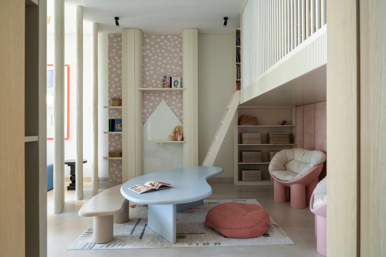 The children's wing: a biomorphic table and fluted plaster columns translate the home's vocabulary into a register a child can inhabit