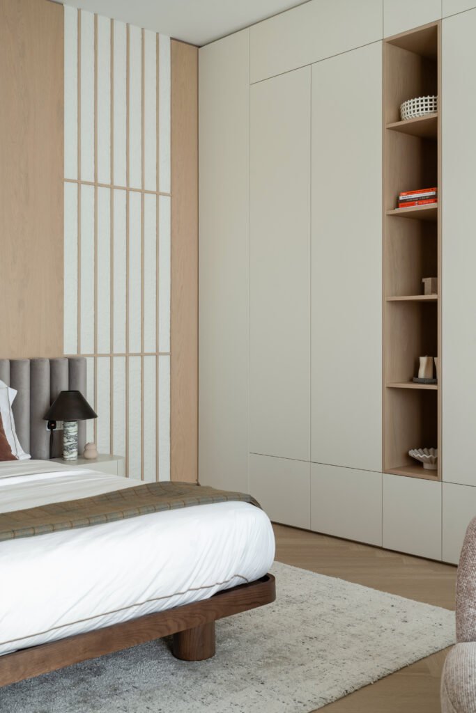 The principal bedroom, where slatted joinery and a low walnut platform bed propose a more Japanese kind of calm