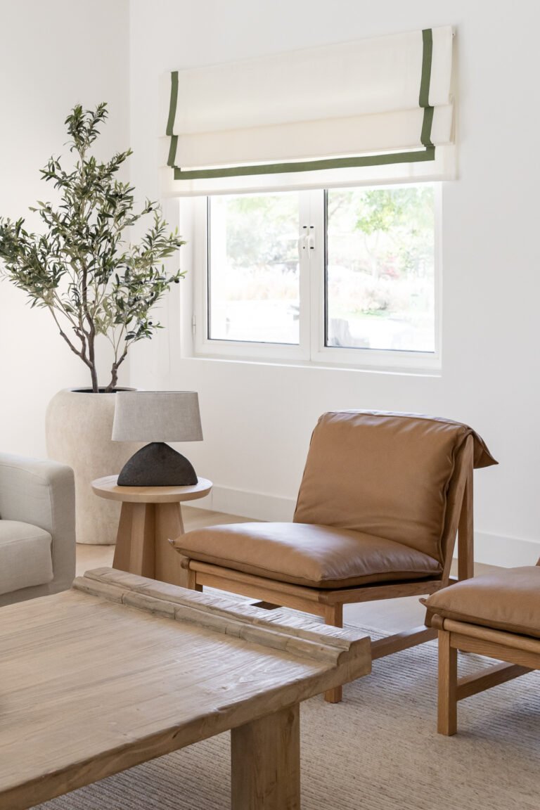 Tan leather lounge chairs introduce a warmer temperature against the room's predominant oatmeal palette