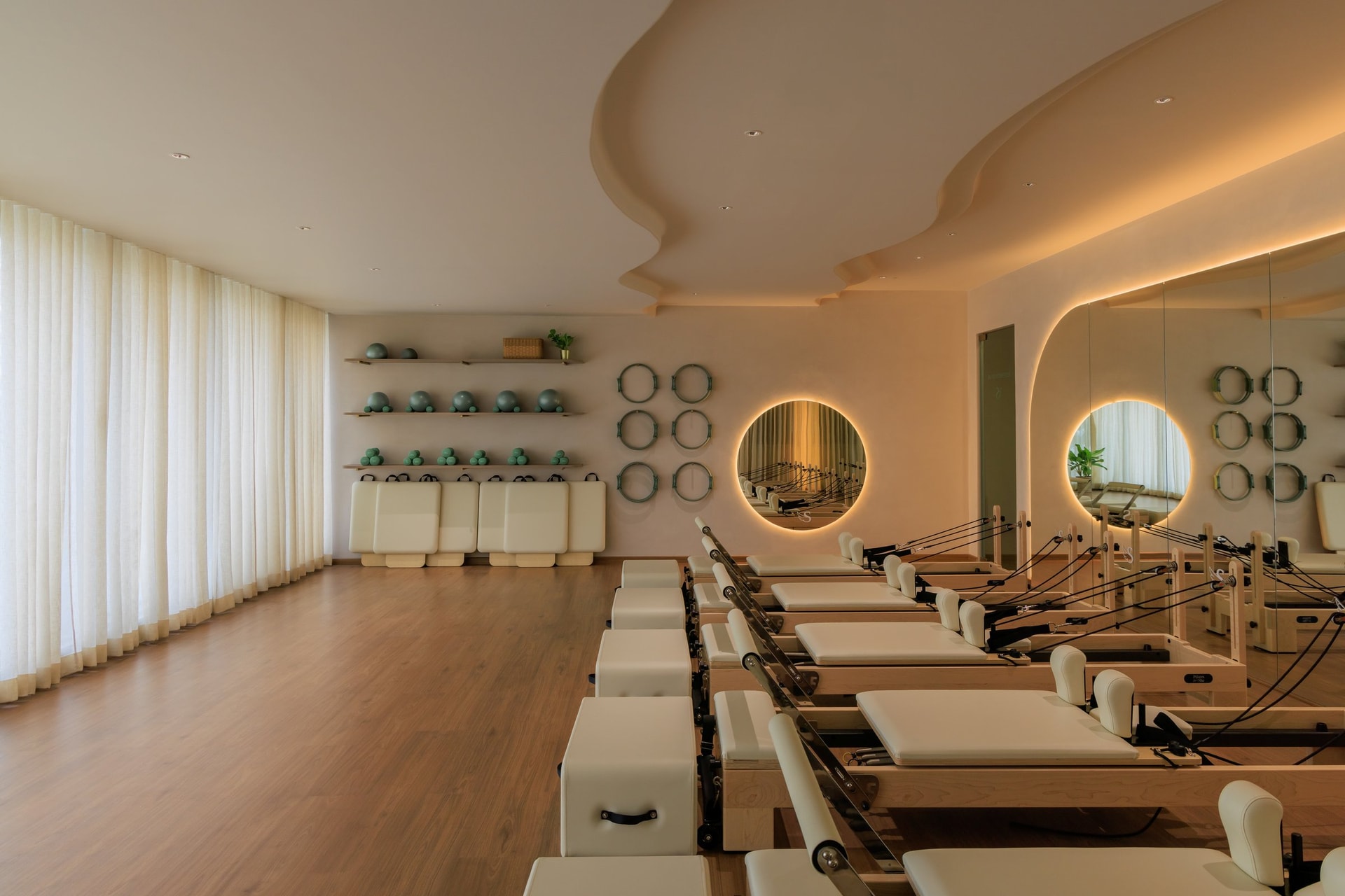 The reformer studio, where backlit circular mirrors hover above each apparatus