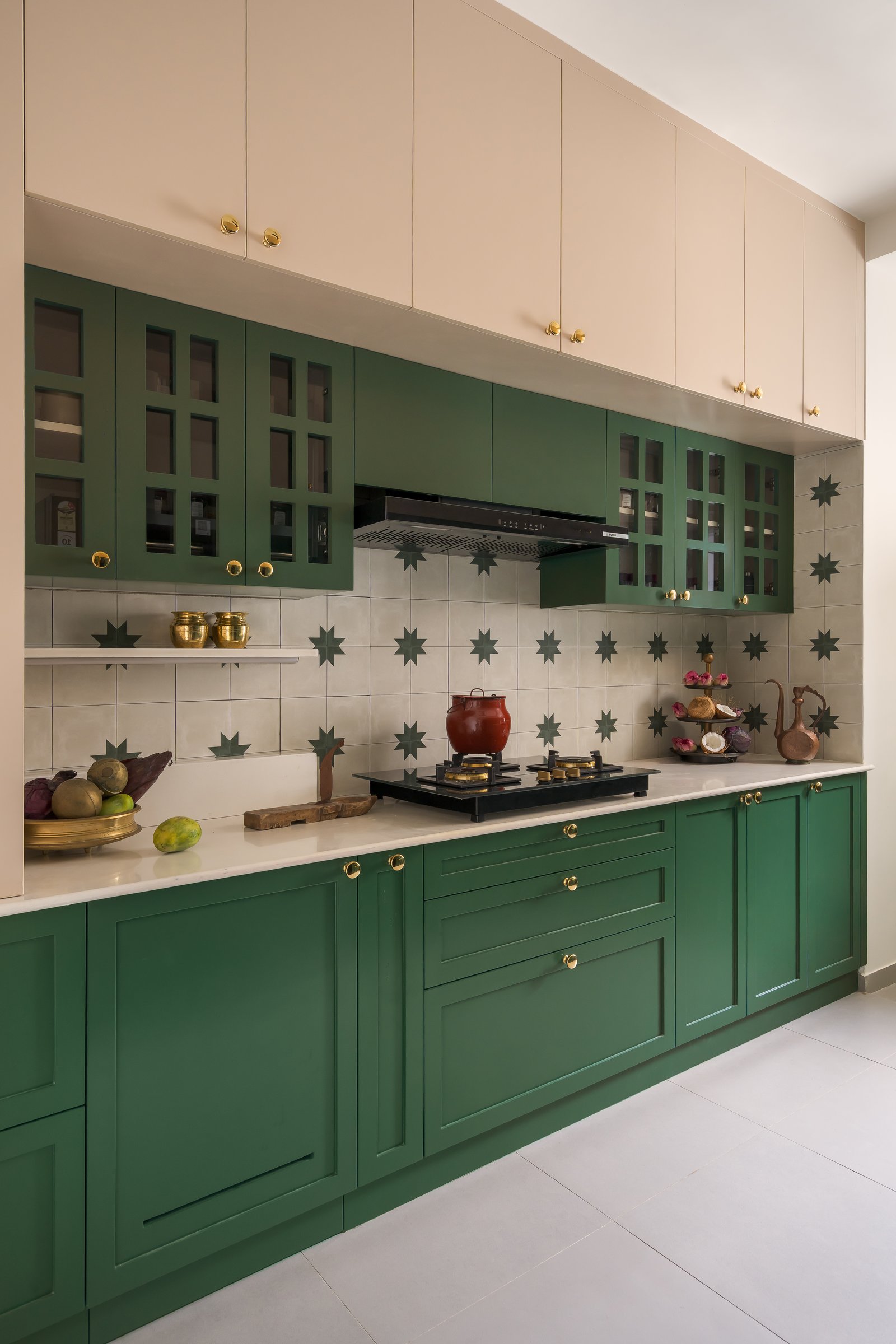 The kitchen, where vintage green joinery meets a patterned cement-tile backsplash with dark green eight-point stars