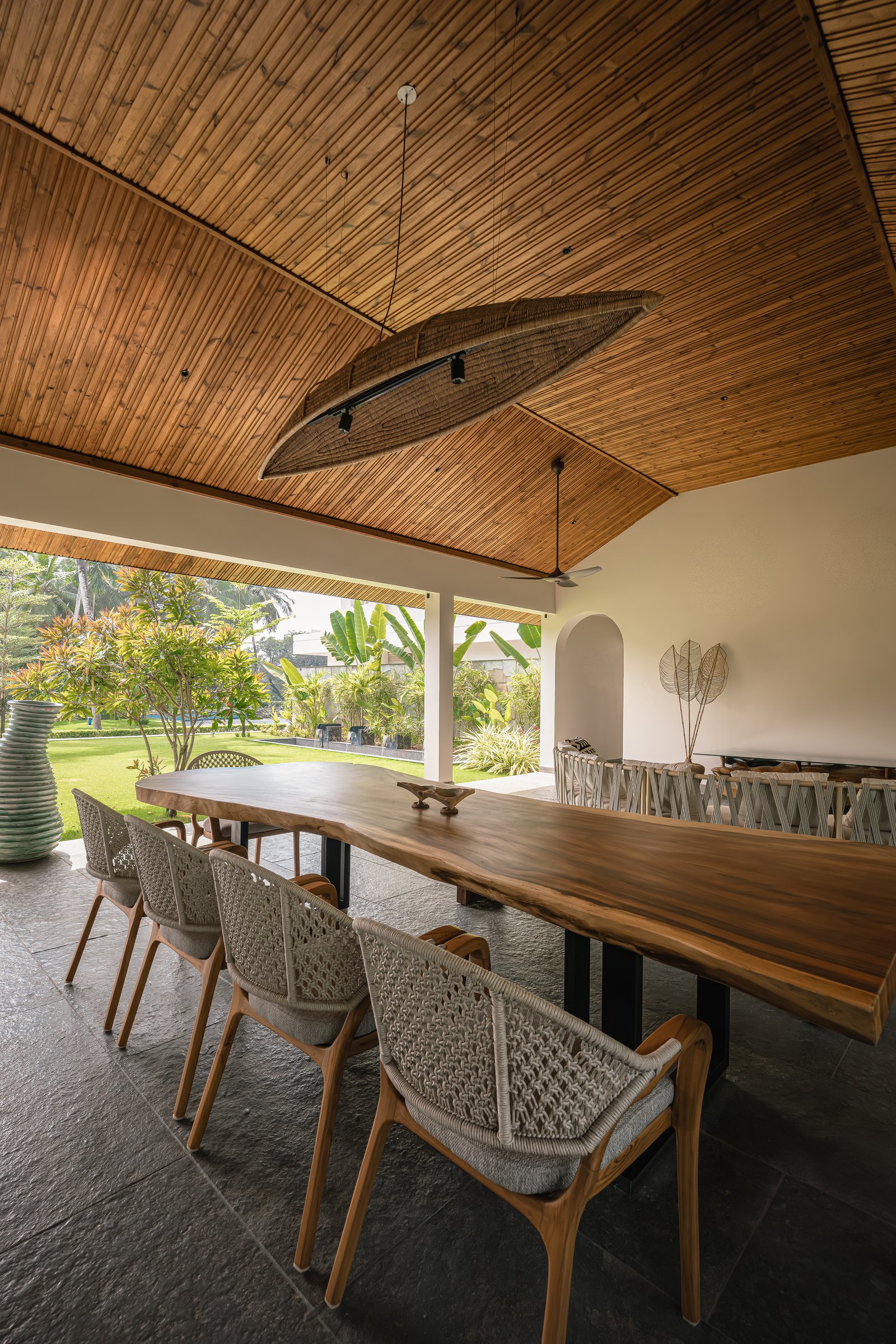 The open edge of the pavilion, where dining and garden meet with only slender columns between them