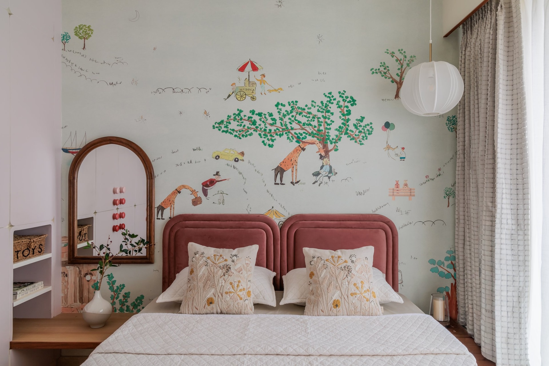The child's bed, its twin arched velvet headboards holding a gentle symmetry against the mural wall