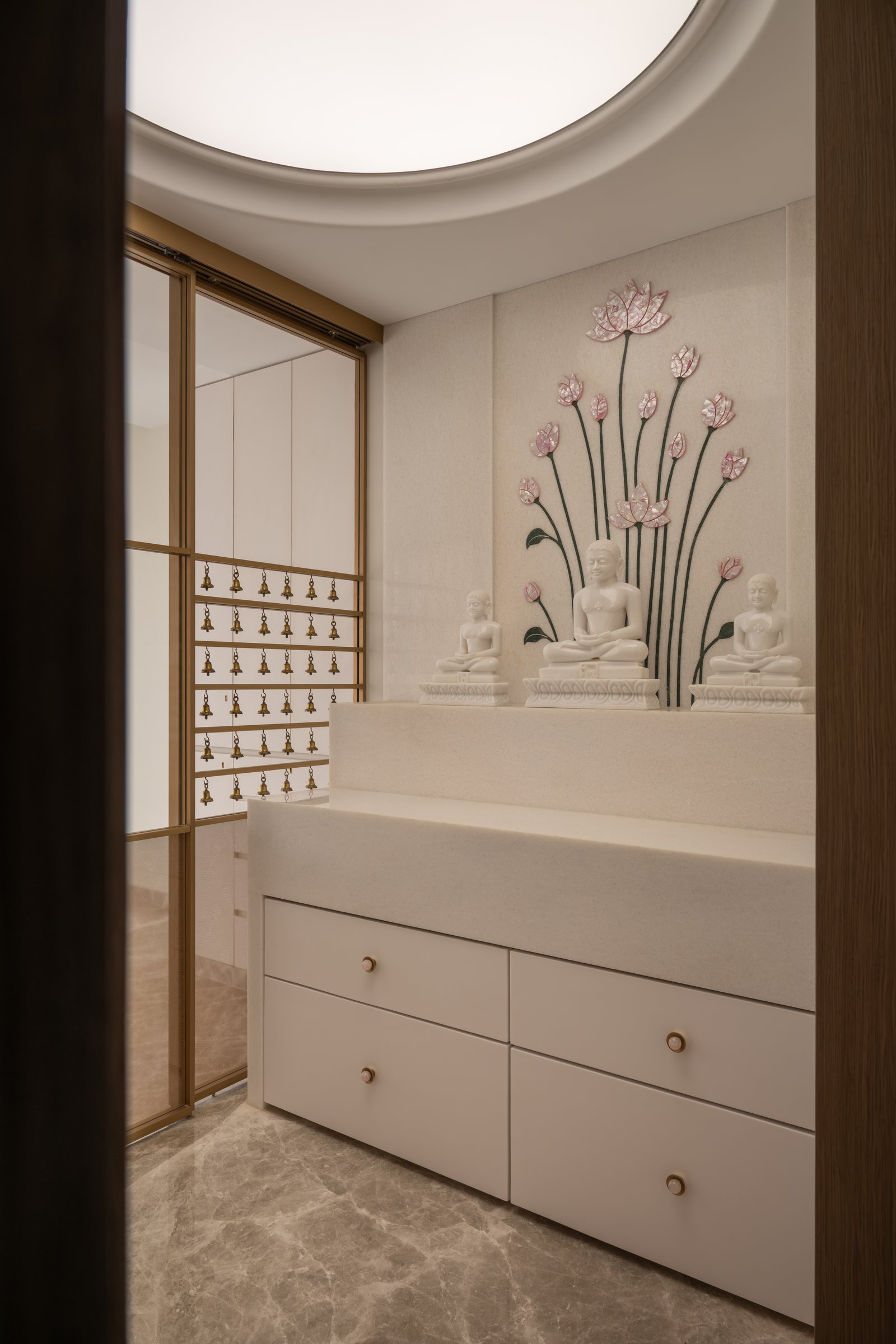 The prayer room, where a lotus mural in coloured inlay and a bell screen frame the family's daily ritual