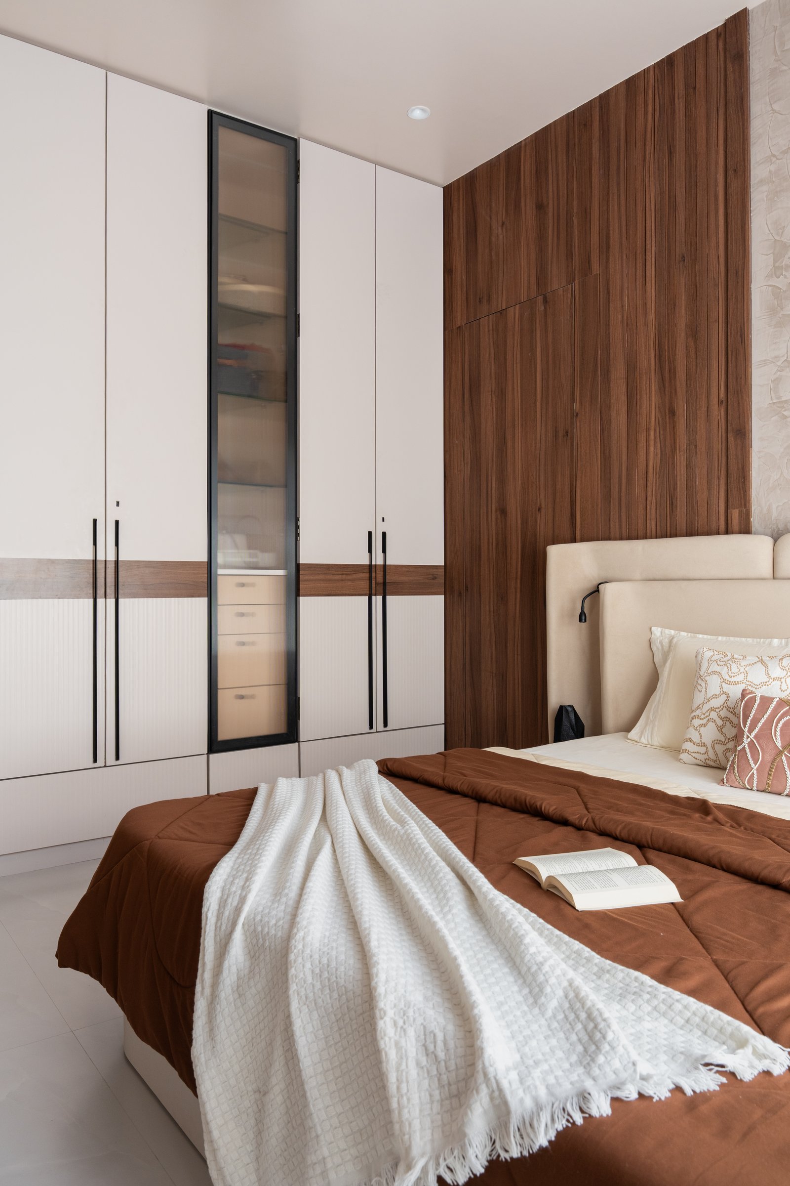 The wardrobe wall in the second bedroom, its white panels and ribbed lower section tied together by a walnut-toned horizontal inlay