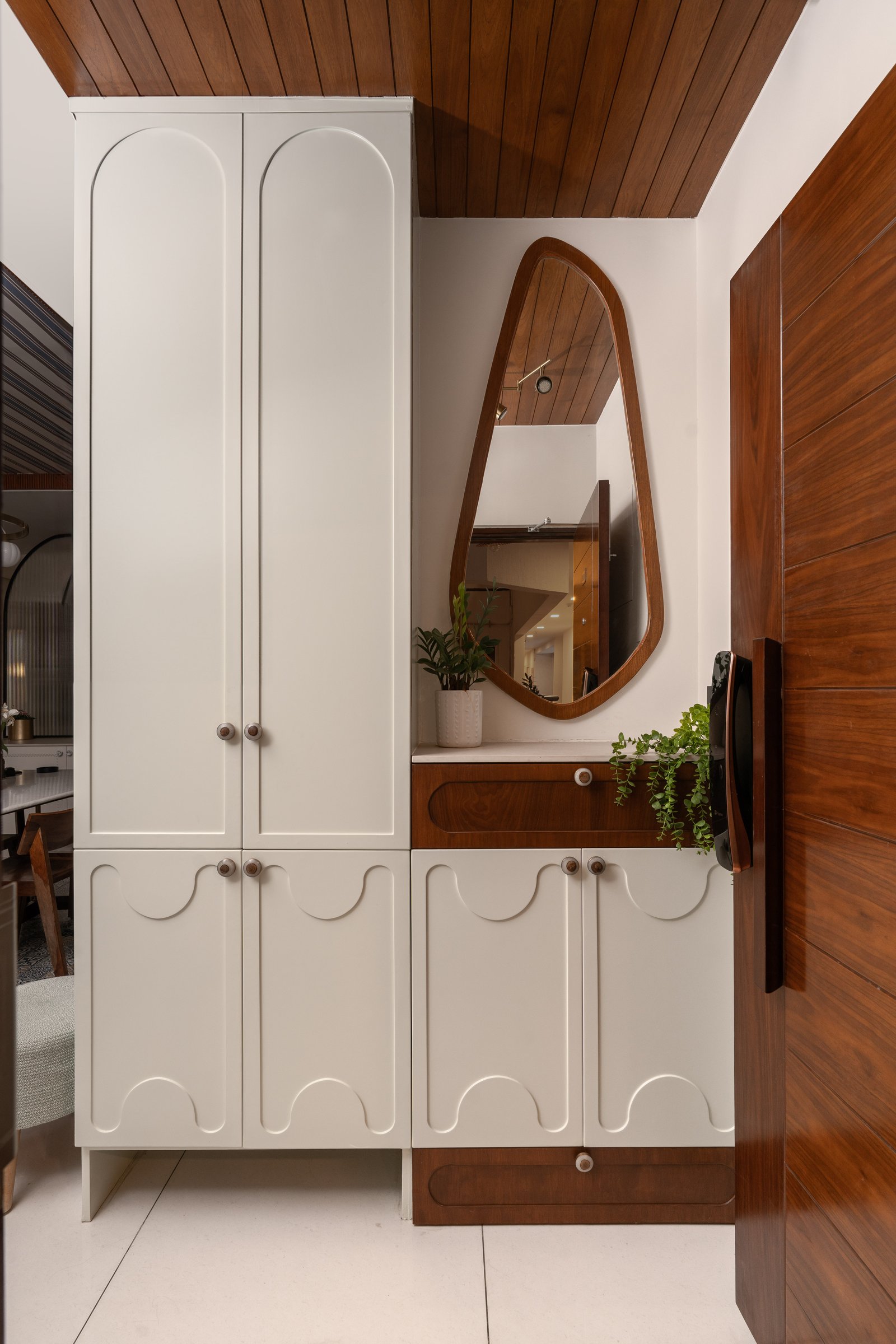The foyer joinery, where arched panels and scalloped detailing introduce the residence's curved geometry
