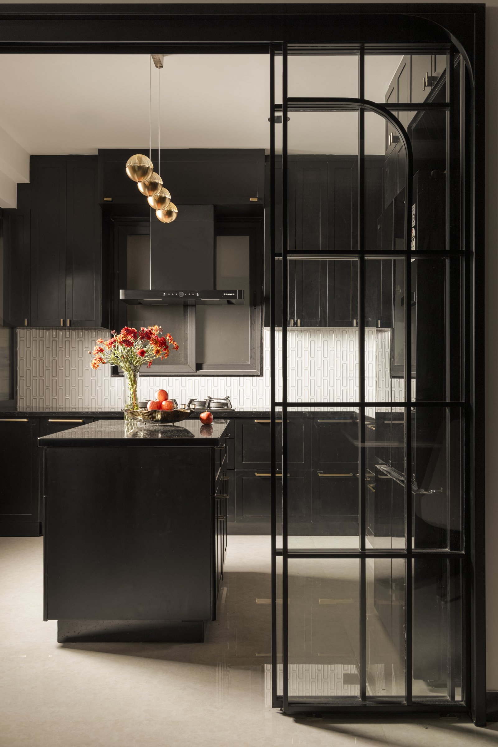 The arched steel-and-glass partition that separates kitchen from dining while preserving sightlines