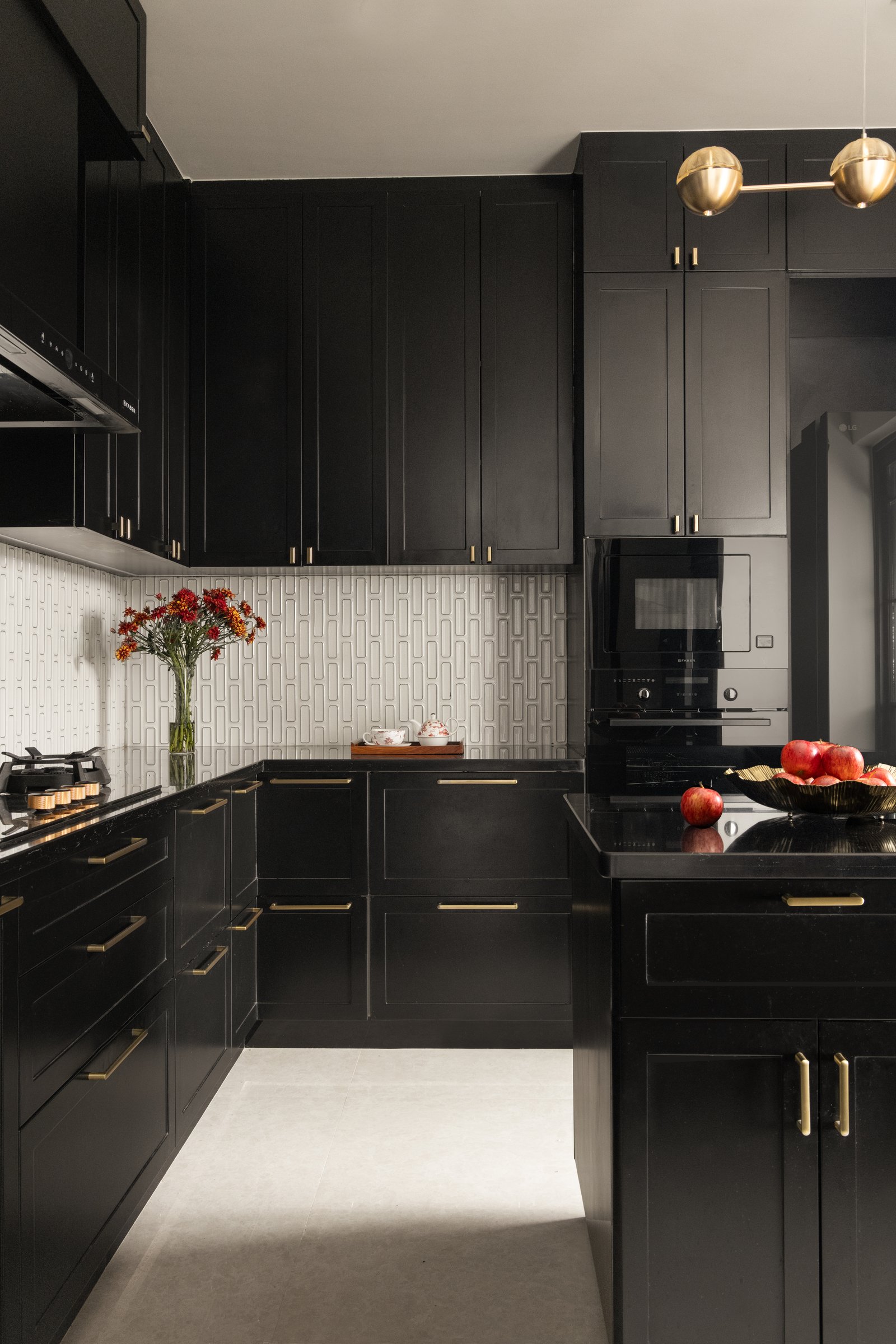 The kitchen, where matte-black shaker cabinetry is relieved by a stadium-patterned tiled backsplash