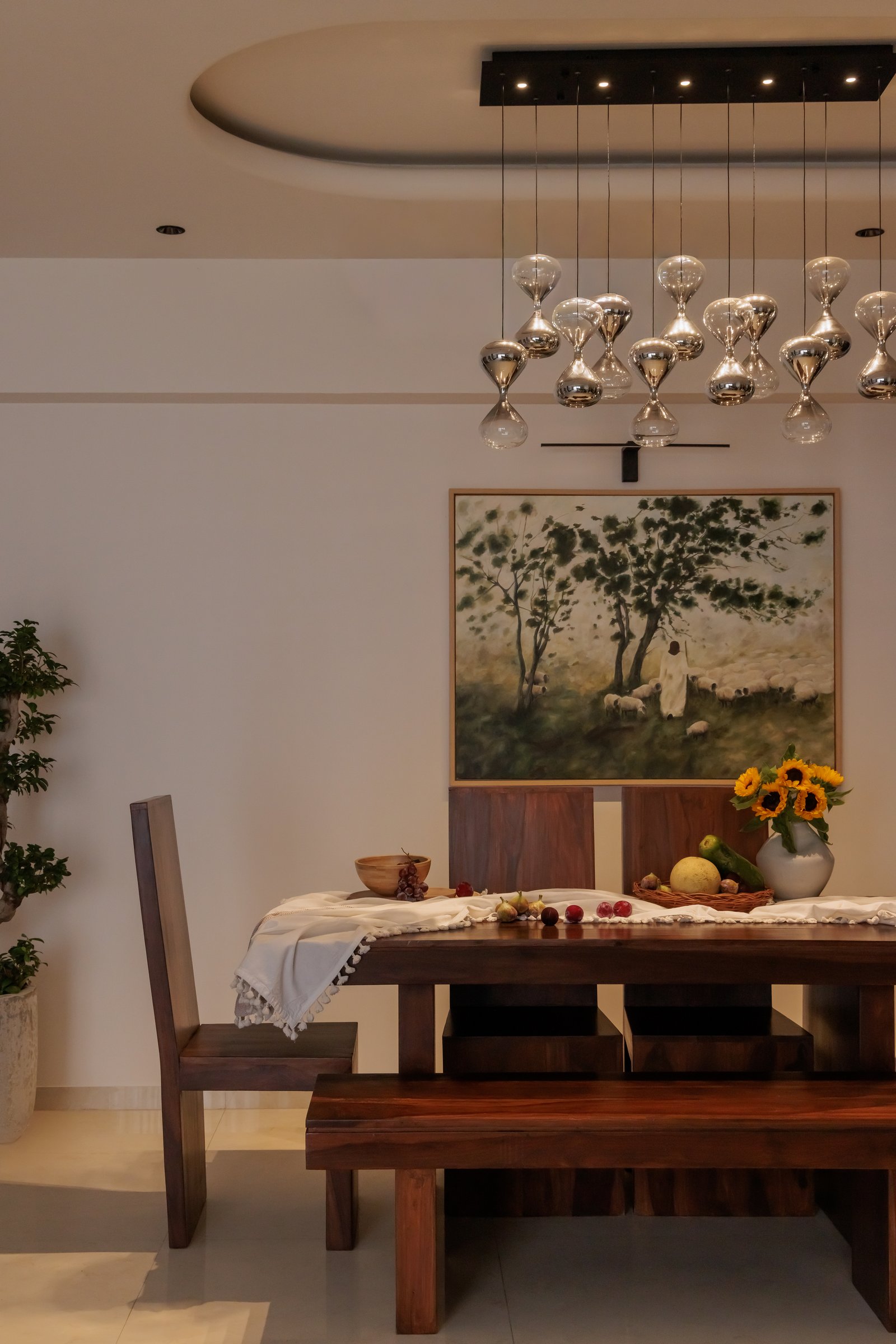 The dining area, anchored by a solid wood table and a cluster of hourglass pendants