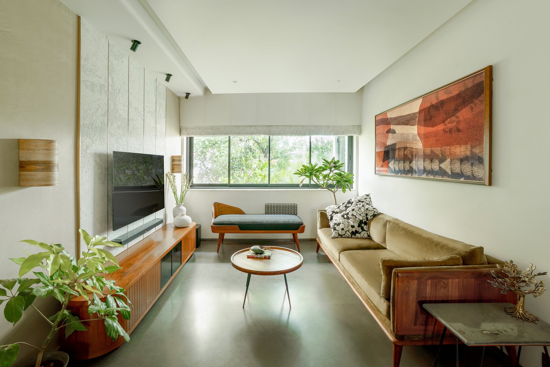 The living room opens onto the tree canopy that shapes the apartment's temperament