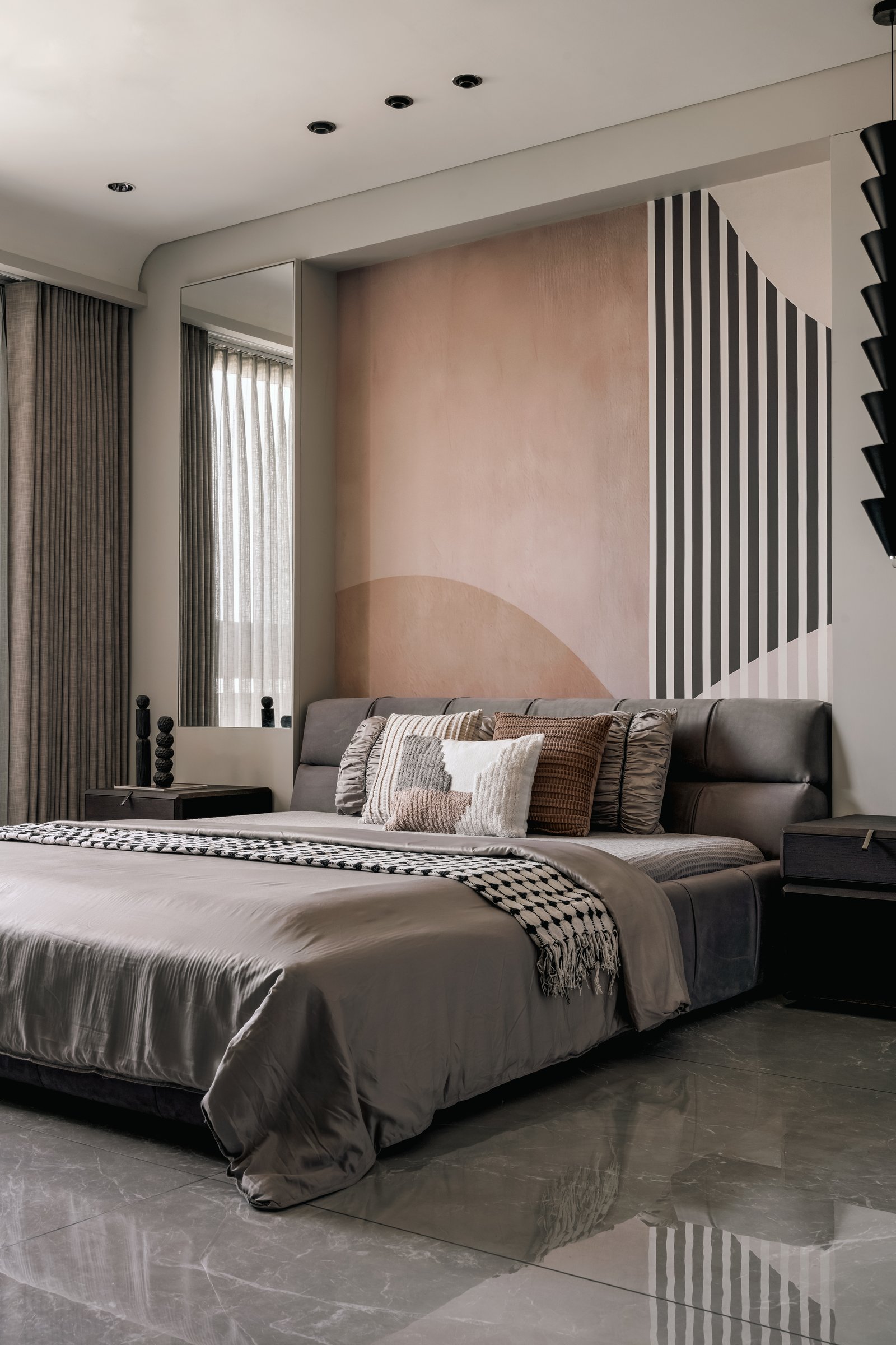 A bedroom anchored by a hand-painted composition of a blush arch overlaid with graphic vertical stripes