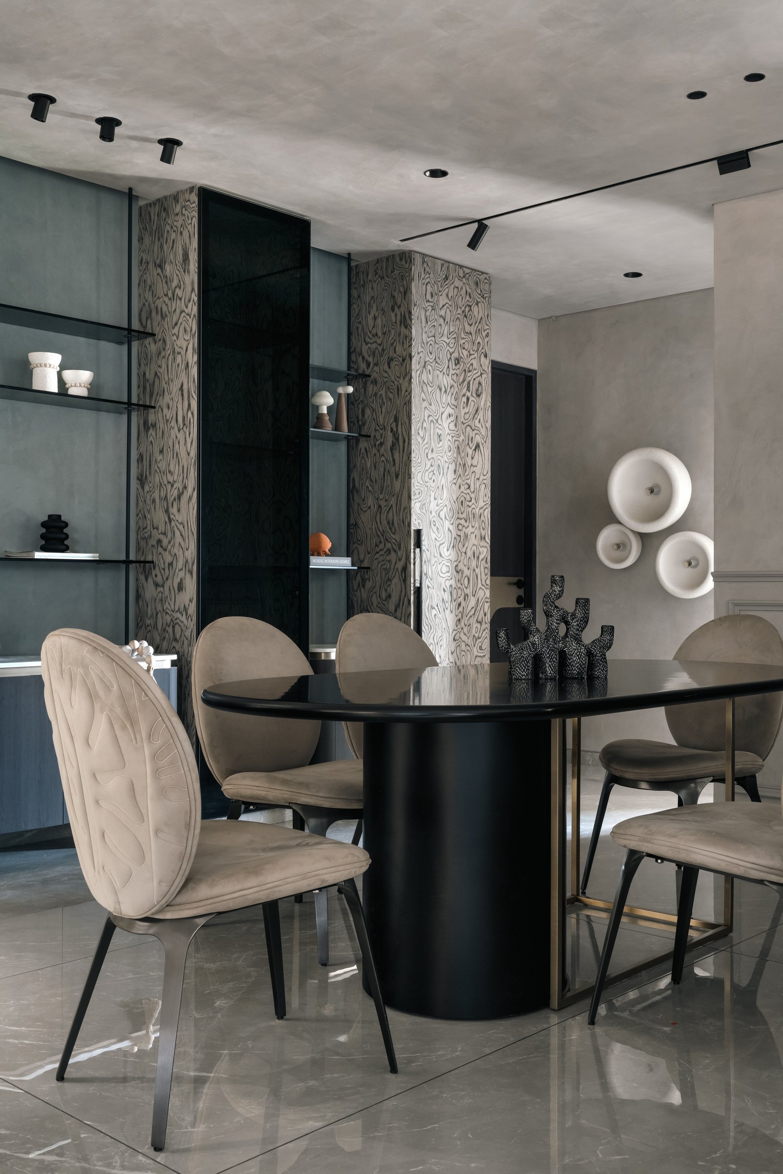 The dining area, where a tall display cabinet in patterned veneer anchors an oval lacquered table