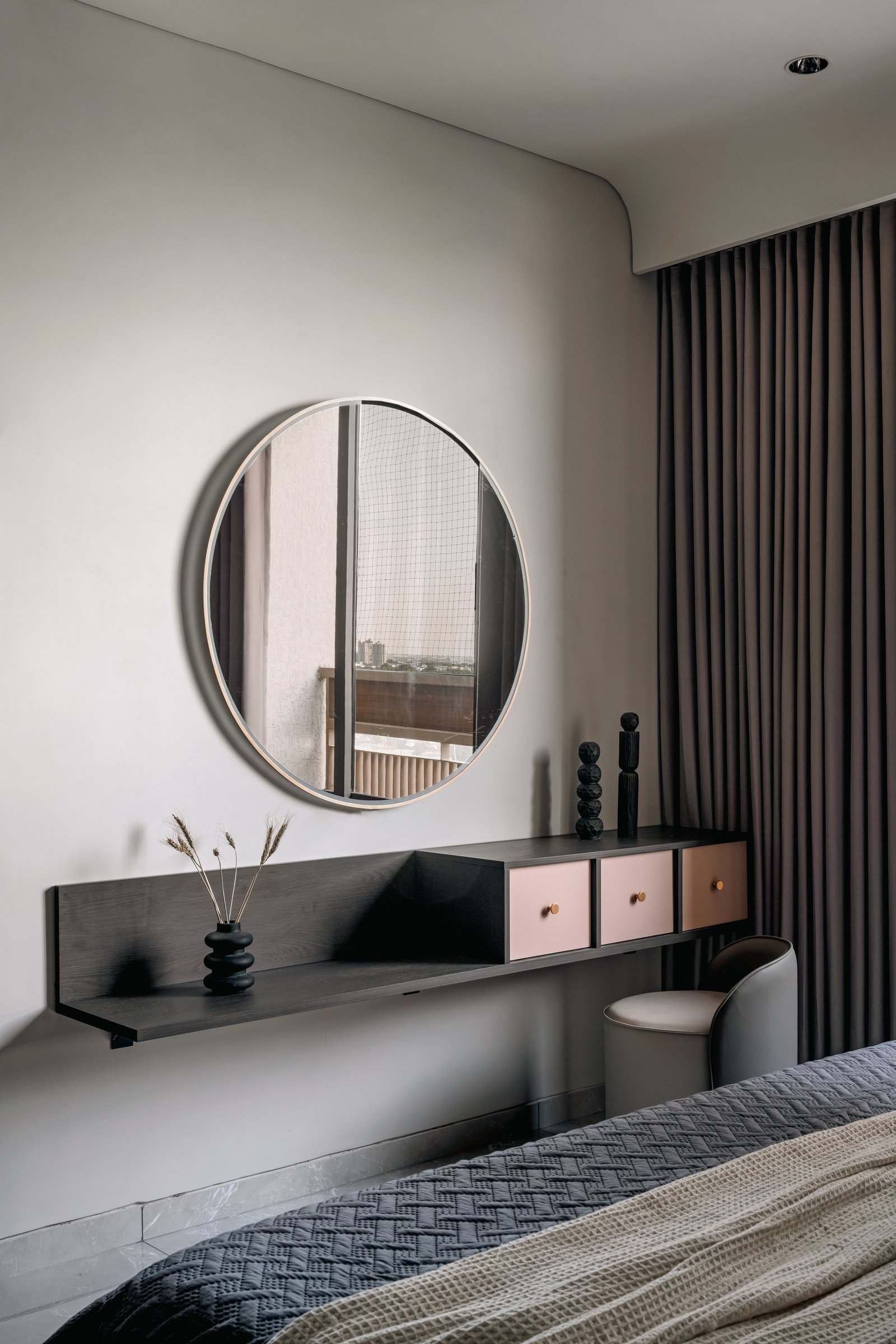 A wall-mounted dressing unit with a circular mirror reflecting the balcony window