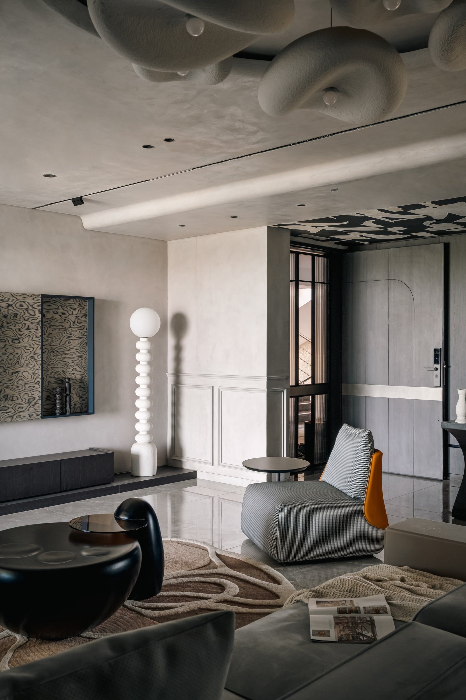 The living room, its cloud-like sculpted ceiling forms suspended within a recessed circular field
