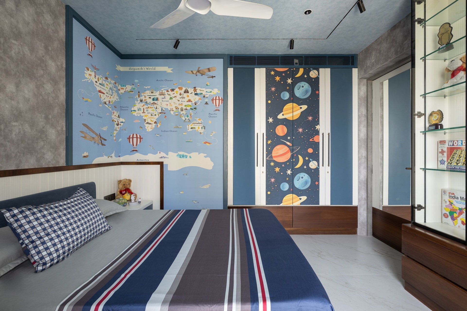 The children's bedroom, anchored by a painted world-map mural and a planetary wardrobe graphic