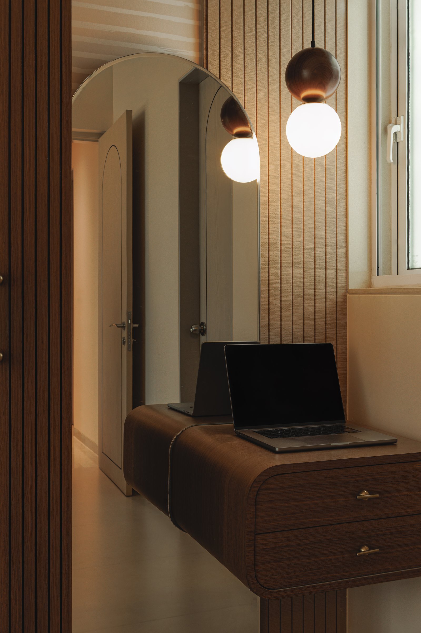 A compact work nook beside the bedroom, where slatted panelling and softened joinery give residual space a considered rhythm