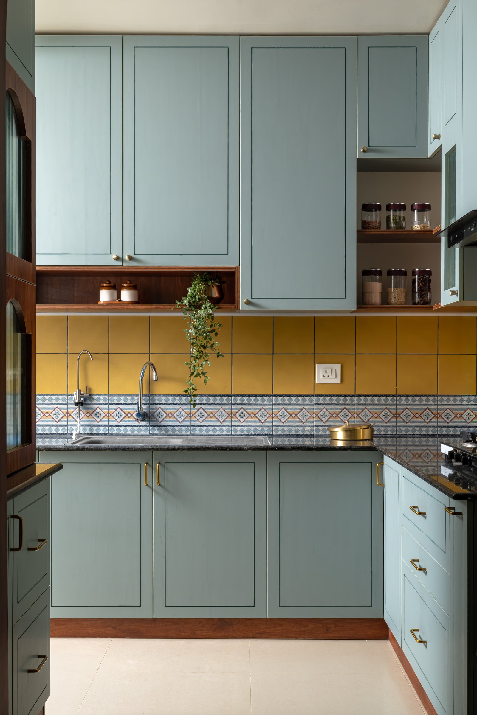 A closer view of the kitchen backsplash, its diamond-geometry border echoing the painted bands elsewhere in the home